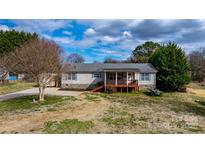 Charming home featuring a quaint front porch, stone accents, and a well-maintained lawn at 1818 Valley Springs Se Dr, Conover, NC 28613