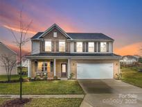 Charming two-story brick home with attached garage and a inviting front porch seating area at 3427 Laurel Oak Ln, Gastonia, NC 28056