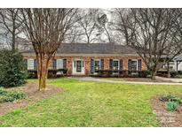 Charming brick home with manicured lawn, mature trees, and black shutters showcasing classic curb appeal at 4132 Sulkirk Rd, Charlotte, NC 28210