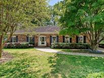 Charming brick home with a well-manicured lawn and lush landscaping surrounding the front entrance at 4132 Sulkirk Rd, Charlotte, NC 28210