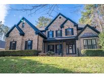 Beautiful brick home featuring a manicured lawn, covered entryway and traditional architectural details at 4268 Rustling Woods Dr, Denver, NC 28037