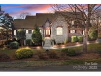 Stunning home with stone and brick facade, manicured landscaping, and elegant entrance stairs at 8034 Bay Pointe Dr, Denver, NC 28037