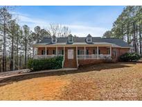 Charming brick home with a welcoming front porch and well-manicured lawn offers classic curb appeal at 201 Olive Rd, Stony Point, NC 28678