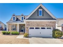 Charming brick home featuring a two-car garage, dormer windows, and a well-manicured lawn at 2314 Talon Point Cir, Fort Mill, SC 29715