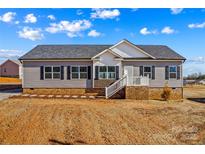 Charming single-story home with gray siding, black shutters, and landscaped front yard under a partly cloudy sky at 447 Lookout Dam Rd, Statesville, NC 28625
