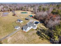 Expansive aerial view of a well-maintained home and property with a pond and outbuildings at 565 Dunns Mountain Church Rd, Salisbury, NC 28146