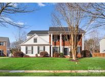 Charming two-story home featuring a well-manicured lawn and a classic brick and siding exterior at 7720 Dinniston Dr, Huntersville, NC 28078