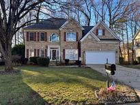 Charming two-story brick home with mature landscaping and a well-manicured front yard at 10216 Willingham Rd, Huntersville, NC 28078