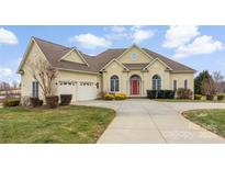 Charming home boasts a manicured lawn, a red front door, and a three-car garage at 103 Caddies Ct, Shelby, NC 28150