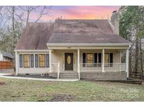 Charming home with a welcoming front porch, beautiful landscape and cozy curb appeal at 11100 Timber Hill Ct, Charlotte, NC 28226