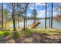 Lake view backyard with private dock surrounded by trees and lush lawn at 2139 Peninsula Dr, Clover, SC 29710