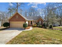 Charming single-story brick home with a well-manicured lawn and attached two-car garage at 214 Bubbling Well Rd, Denver, NC 28037