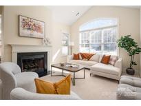 Bright living room with a fireplace, large windows, and a neutral color palette at 2937 Bellasera Way, Matthews, NC 28105