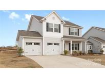 Charming two-story home with a two-car garage and a welcoming front porch at 418 Babbling Brook Ln # 245B, Locust, NC 28097