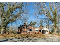 Charming brick home with a cozy front porch and carport nestled under mature trees, perfect for curb appeal at 801 Requa Rd, Cherryville, NC 28021
