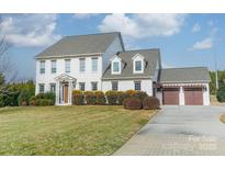 Charming white two-story home with attached garage and well-manicured lawn on a sunny day at 2027 Gloucester St, Matthews, NC 28104