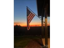Inviting front porch view featuring an American flag against a scenic sunset backdrop at 2288 Boheler Rd, Clover, SC 29710