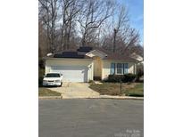 Charming single-story home featuring a driveway, garage, solar panels, and manicured landscaping at 3002 Willamette Valley Dr, Charlotte, NC 28215