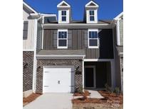 Charming two-story townhome featuring a brick facade, attached garage, and dormer windows at 3509 Nimbell Rd, Monroe, NC 28110