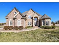 Beautiful brick and stone home with mature landscaping and arched front entry at 4812 Campobello Dr, Monroe, NC 28110