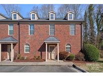Charming multi-story brick townhome featuring dormer windows and well-maintained landscaping at 653 Camrose Ne Cir, Concord, NC 28025