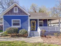 Charming blue house featuring a yellow front door and cozy front porch at 734 Herrin Ave, Charlotte, NC 28205