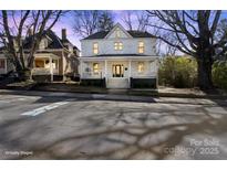 Charming two-story home with a welcoming front porch, enhanced by mature trees and a well-maintained lawn at 85 Grove Nw Ave, Concord, NC 28025