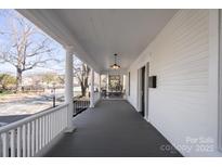 Expansive front porch offers a relaxing outdoor space with classic white railings and a view of the neighborhood at 85 Grove Nw Ave, Concord, NC 28025