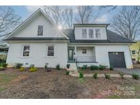 Charming two-story home with a manicured lawn, fresh white paint, and inviting front entry at 908 Stanfield Dr, Charlotte, NC 28210