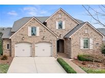 Charming brick home with a two-car garage and well-manicured landscaping at 9223 Robbins Preserve Rd, Cornelius, NC 28031