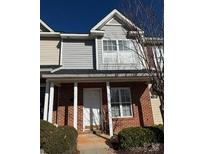Charming townhome with brick facade and covered front porch offers curb appeal at 122 Barnhardt Loop, Mooresville, NC 28117