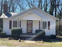 Charming one-story home featuring a classic design, inviting front porch and a neatly landscaped front yard at 122 E Hargrave St # 50, Wadesboro, NC 28170