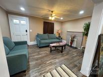 Cozy living room featuring hardwood floors, fireplace, ceiling fan, and neutral paint at 122 E Hargrave St # 50, Wadesboro, NC 28170