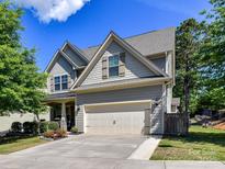 Charming two-story home with a two-car garage and beautifully landscaped front yard under a bright blue sky at 16404 Mckee Ridge Dr, Charlotte, NC 28278