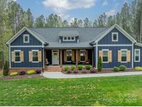 Charming blue home featuring a brick-lined porch, shutters, and landscaped yard at 2125 Partridge Berry Ln, Rock Hill, SC 29730