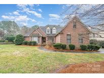 Beautiful brick home featuring manicured landscaping and a well-maintained lawn at 5125 Belicourt Dr, Charlotte, NC 28277