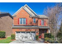 Charming two-story brick home with a well-manicured lawn and a two-car garage at 615 Bourton House Dr, Charlotte, NC 28211