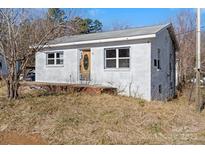 Charming white brick home featuring a quaint front porch, perfect for enjoying quiet mornings at 6230 Old Mocksville Rd, Salisbury, NC 28144