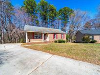 Charming brick home featuring a spacious front yard and a concrete driveway at 702 Selma Burke Ln, Matthews, NC 28105
