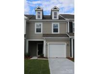 Charming two-story townhome features a one-car garage and neutral siding at 795 Earhart Nw St, Concord, NC 28027