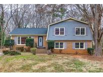 Charming two-story home with a brick facade, gray siding, and mature trees at 8106 Sidras Ct, Charlotte, NC 28270
