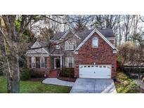 Charming two-story brick home featuring a two-car garage and mature landscaping at 105 Millwood Dr, Fort Mill, SC 29715