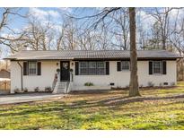 Charming brick home with black trim, metal roof, and landscaped yard on a sunny day at 1106 Forest Dr # 75, Marshville, NC 28103