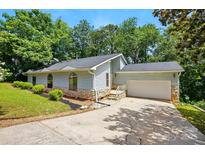 Charming single-story home with a two-car garage, stone accents, arched windows and a well-maintained lawn at 1205 Molokai Dr, Tega Cay, SC 29708
