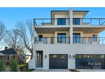 Modern multi-story home with black framed windows, balconies, and a two-car garage, offering stylish living at 302 Marsh Rd, Charlotte, NC 28209