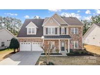 Charming two-story home with a stone facade, inviting front porch, manicured lawn, and three-car garage at 3563 Valiant Sw Ave, Concord, NC 28027