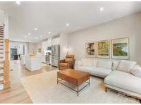 Bright, open-concept living room featuring hardwood floors, modern decor, and seamless access to the kitchen at 4010 Citra Ln, Charlotte, NC 28217