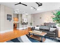 Contemporary living room boasts hardwood floors, modern lighting, and open layout to the kitchen and dining area at 404 N Laurel Ave # 18, Charlotte, NC 28204