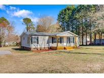 Charming single-story home with gray siding, black shutters, and a cozy front porch at 8670 Carroll St, Hickory, NC 28601