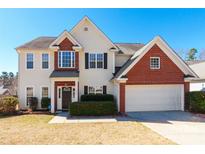 Charming two-story home features a brick and siding facade, attached two-car garage, and manicured front yard at 1066 Streamlet Way, Monroe, NC 28110